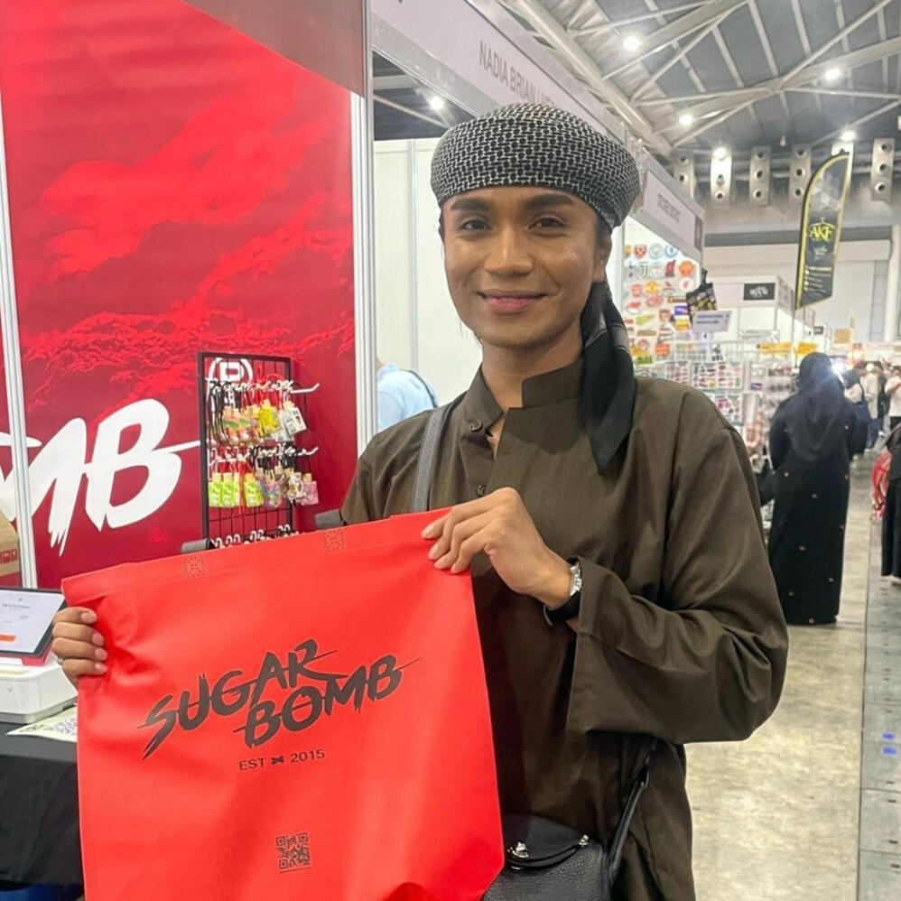 A satisfied shopper holding a SugarBomb SG bag, showcasing the best perfume store deals for long-lasting inspired scents in Singapore.